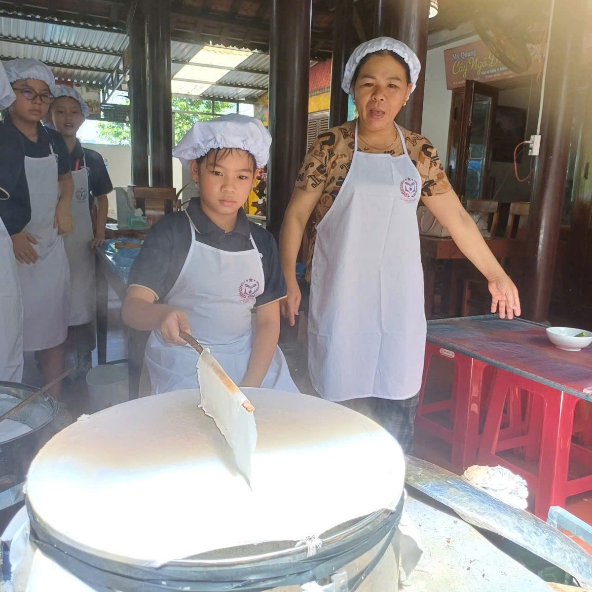 Tấm bánh chín tới được nâng nhẹ bằng chiếc nẹp trúc, bóng mượt và thơm phức mùi gạo mới